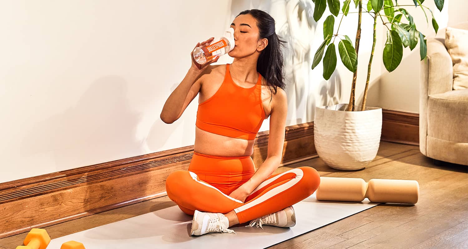 Woman drinking water while exercising